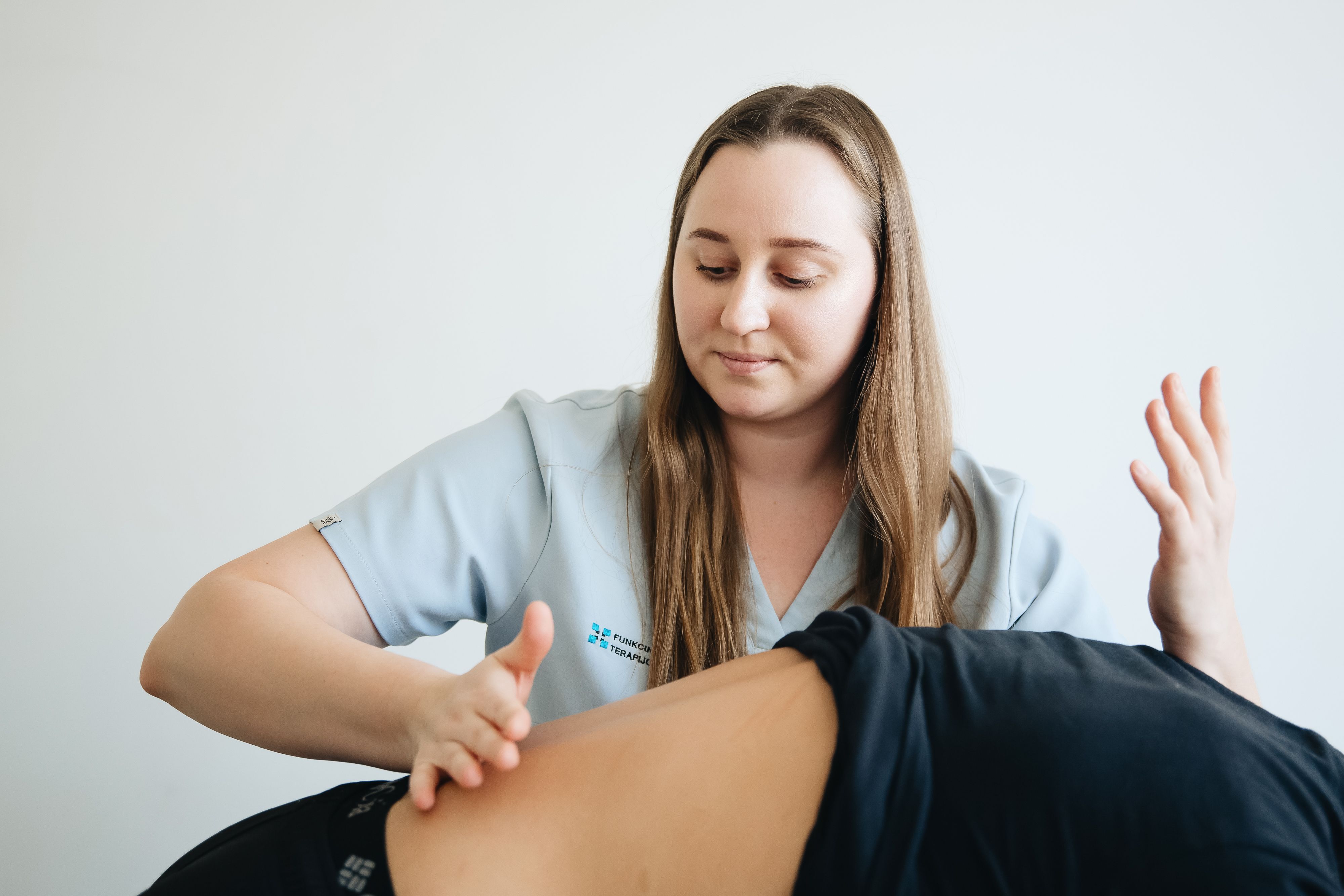 Eine Physiotherapeutin arbeitet konzentriert und einfühlsam mit einer Patientin.
